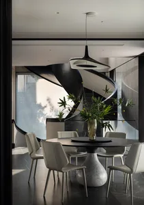 Modern dining room with marble table and chairs, featuring a contemporary light fixture and a vase of greenery.