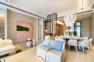 A modern dining room featuring white fabric chairs and a round table.
