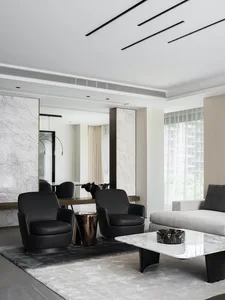 Modern living room with marble coffee table and black armchairs.