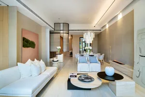 A stylish and contemporary living room featuring marble elements and modern furniture.