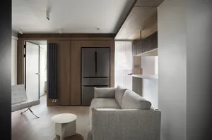Modern minimalist living room featuring wooden furniture and a white sofa, showcasing a sleek, contemporary design.