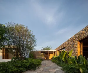 A modern residential space with concrete, stone, and wooden elements.