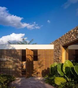 Modern residential exterior with wooden lattice panels and stone walls
