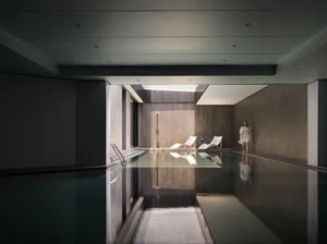 Modern spa interior with glass water feature and stone walls.