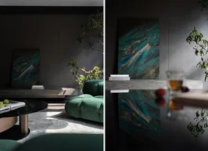 Modern living room with dark grey walls, floating wooden shelf, and green couch.