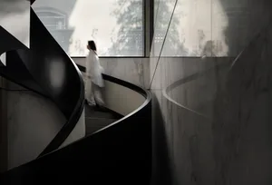 Minimalist concrete staircase with large windows and natural light.