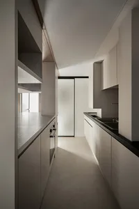 Modern kitchen with concrete countertops, glass cabinets, and stainless steel appliances