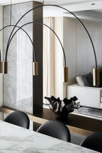 A modern dining room featuring a marble table, black leather chairs, and minimalist decor.