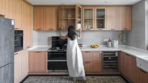 A modern kitchen featuring wooden cabinets and marble countertops.