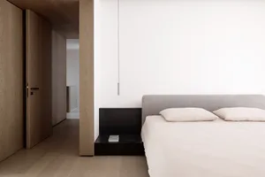 Minimalist bedroom featuring a textured wood floor and marble countertop