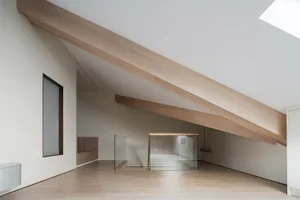 Modern living area with wooden beams and glass panels.