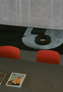 A magazine display with red chairs and a glass table, featuring a magazine titled 'Atmos'.