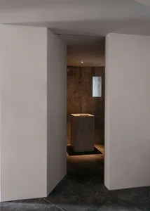 A minimalist interior space with a marble object in the center.