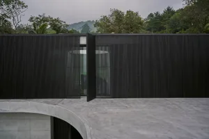 A modern house with a black striped fence and a minimalist design.