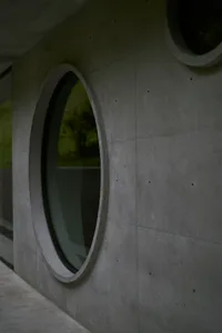 A modern concrete exterior featuring circular windows.