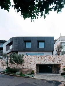 Modern house with concrete, glass, and stone exterior.