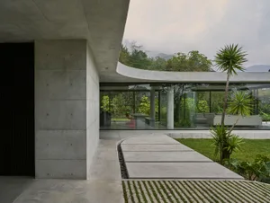 Modern minimalist exterior of a residential home featuring concrete and glass materials.