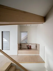 A minimalist living room with wooden flooring and built-in seating.