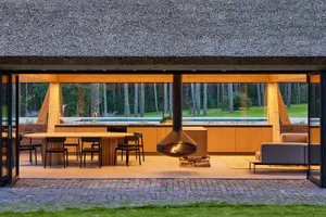 Contemporary barn-style outdoor kitchen featuring wooden elements and a hanging fireplace