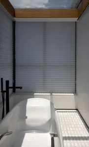 Modern bathroom with white tiles, glass shower enclosure, and freestanding tub.
