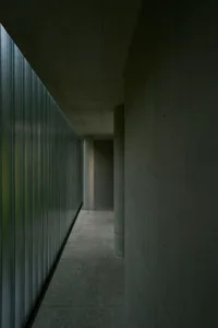 Minimalist design corridor featuring concrete and glass materials.