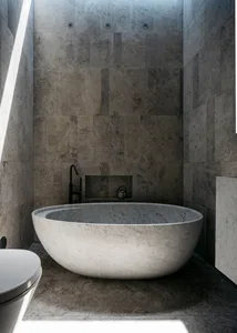 A modern bathroom with a minimalist design, featuring a freestanding marble bathtub and gray marble tiles on the walls.