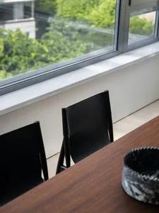 Modern dining room with dark wooden table and black leather chairs.