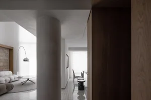 Contemporary living room with white marble finishes, sleek minimalist furniture, and a spacious design.