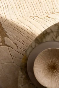 Minimalist interior design featuring textured marble floor and decorative marble bowl.