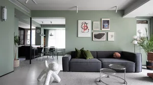 A modern living room featuring a fabric sofa, glass coffee table, and metal accents.