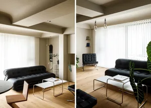 A modern minimalist living room featuring wood flooring and minimalist furniture, with vertical blinds on the windows and a s