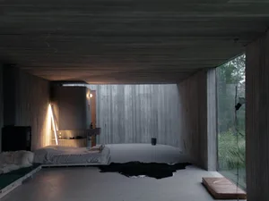 Minimalist bedroom with concrete walls, floor, and ceiling, designed for privacy and simplicity