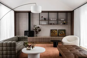A modern living room featuring leather sofas, concrete floor, and minimalist decor.