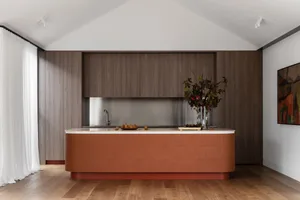 A modern kitchen featuring a terracotta-tiled countertop and marble accents.