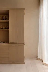 A minimalist kitchen storage unit made of wood, featuring sleek lines and simple design.