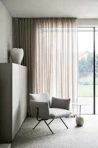 Modern living room featuring gray furniture, lighting, and concrete elements.
