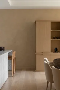 Modern minimalist kitchen and dining area featuring wooden furniture and marble countertop.