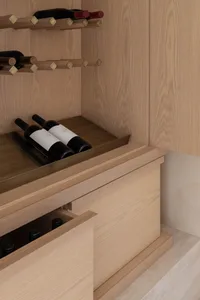 Modern wine cabinet with wooden and brass components.