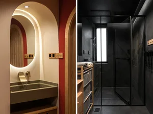 A modern bathroom featuring a black glass walk-in shower, wooden furniture, and a sleek, minimalist design.