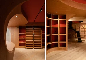 Modern closet with red walls and wooden shelves.