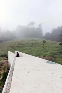 Modern concrete landscape with grassy hills and foggy background.
