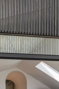 Industrial-style interior with metal and glass architectural elements and a curved archway.