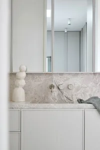 A modern, minimalist bathroom featuring marble countertops and minimalist design elements.