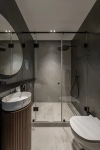 Modern bathroom with marble shower, sink, and toilet