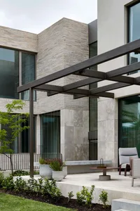 An image showing a modern terrace with concrete flooring and glass accents.