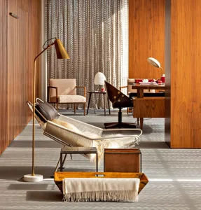 A modern office space featuring wooden walls, a comfortable lounge chair, and a functional workspace.