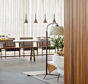 A modern dining room with wooden furniture and pendant lights.