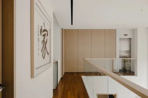 Modern residential corridor featuring wooden flooring and a glass railing.