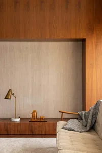 Modern living room featuring wooden furniture, a cozy armchair, and a minimalist decor.