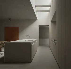 A minimalist kitchen with a concrete island and white cabinets.